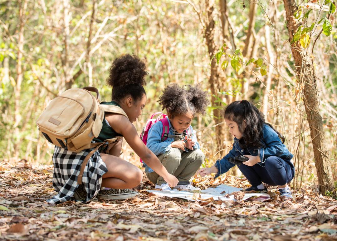 enfants qui observent une carte au sol et la nature